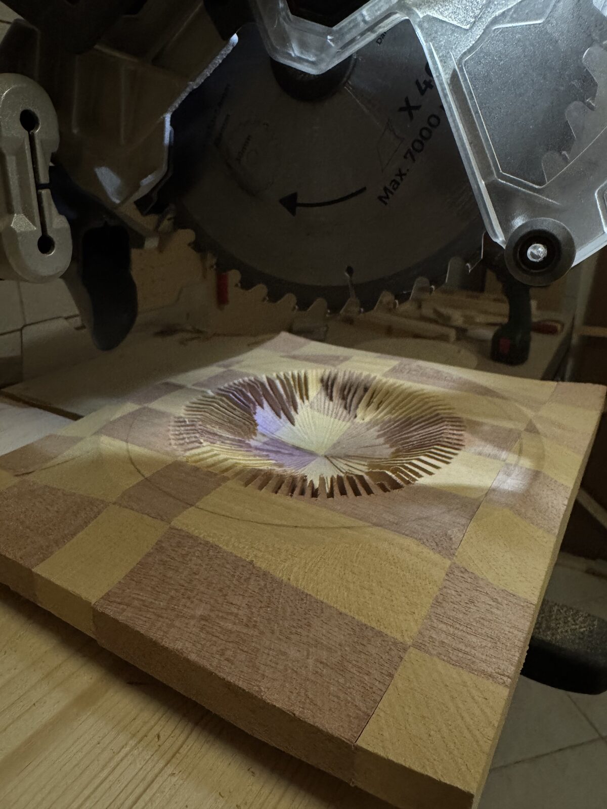 Pezzo dalle forme geometriche in lavorazione sotto la lama della sega