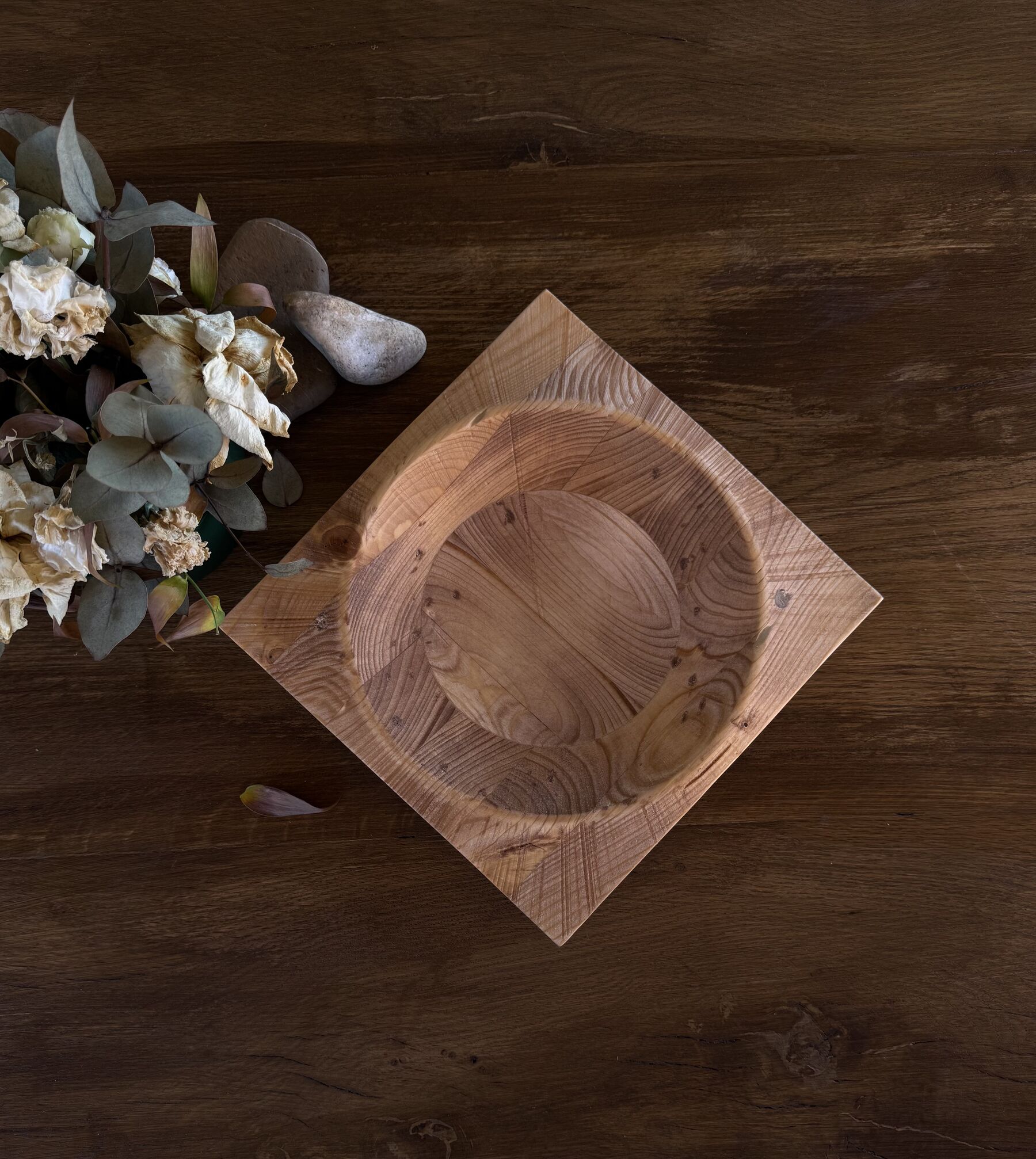 Fossile, svuotatasche scultoreo in legno di abete a forma di rombo, su un tavolo in legno con fiori secchi e una pietra